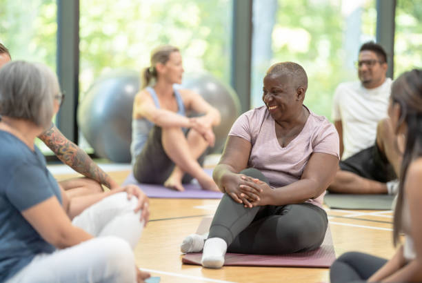 Femmes qui font connaissance en début de cours de yoga adapté cancer