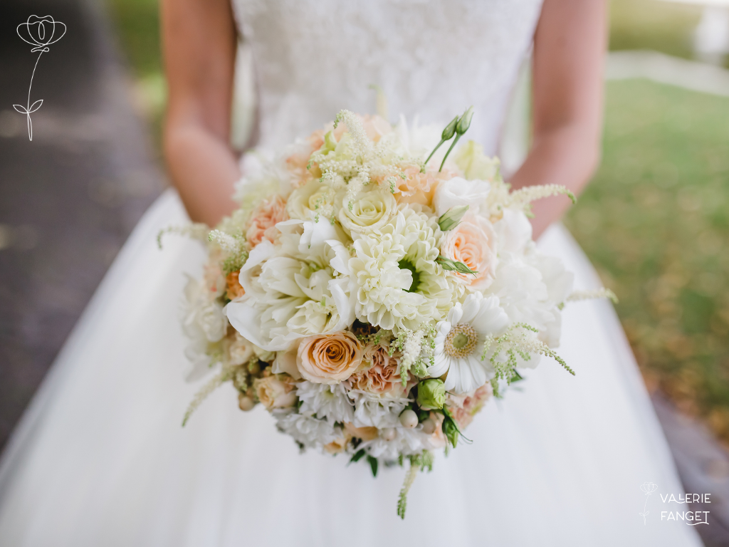 Gros plan sur un bouquet de mariée tenue par la mariée